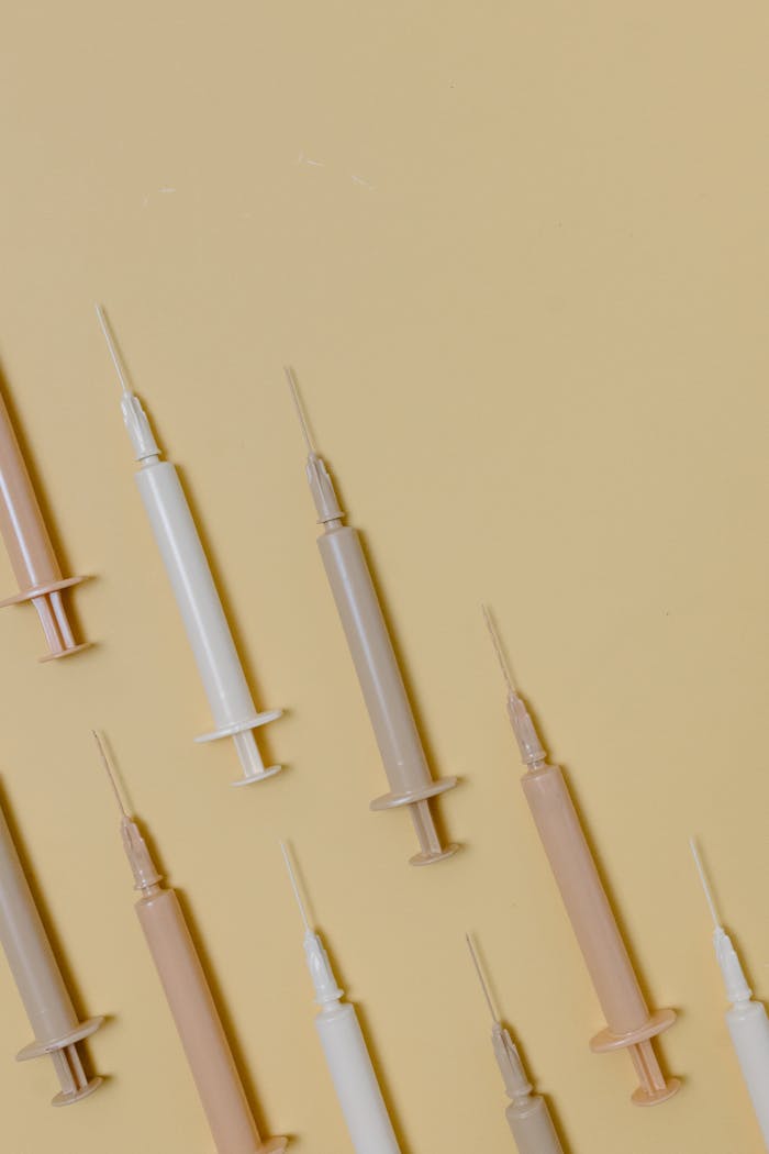 A collection of syringes arranged on a pastel surface, ideal for healthcare themes.